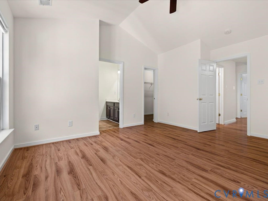 Vaulted ceiling, wood-finish flooring, white paneled doors, ceiling fan