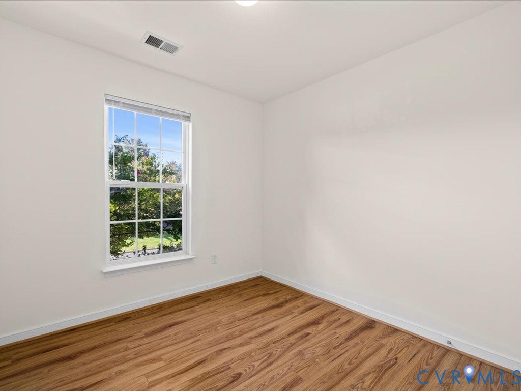 Crisp white walls, wood-finish flooring, and a single-pane window