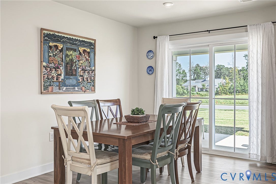 7490 E Danube Loop, The Groves, New Kent, VA 23124 Dining area with sliding glass doors framing peaceful pond and green space views