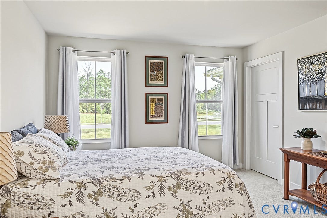 7490 E Danube Loop, The Groves, New Kent, VA 23124 Spacious primary bedroom with large windows bringing in natural light and pond views