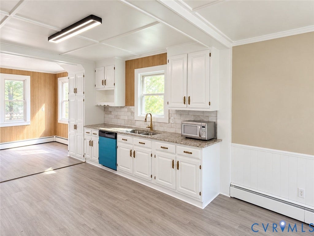 207 S Mesa Drive, Hopewell, VA 23860 White shaker-style cabinetry with gold-tone hardware, a light-colored speckled countertop, a white subway tile backsplash, and wood-finish flooring