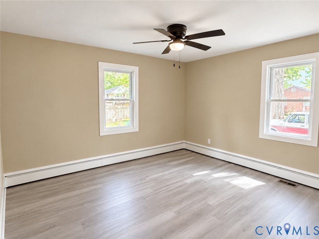 207 S Mesa Drive, Hopewell, VA 23860 Neutral wall color, wood-finish flooring, white window trim, dual windows, and a ceiling fan with integrated lighting
