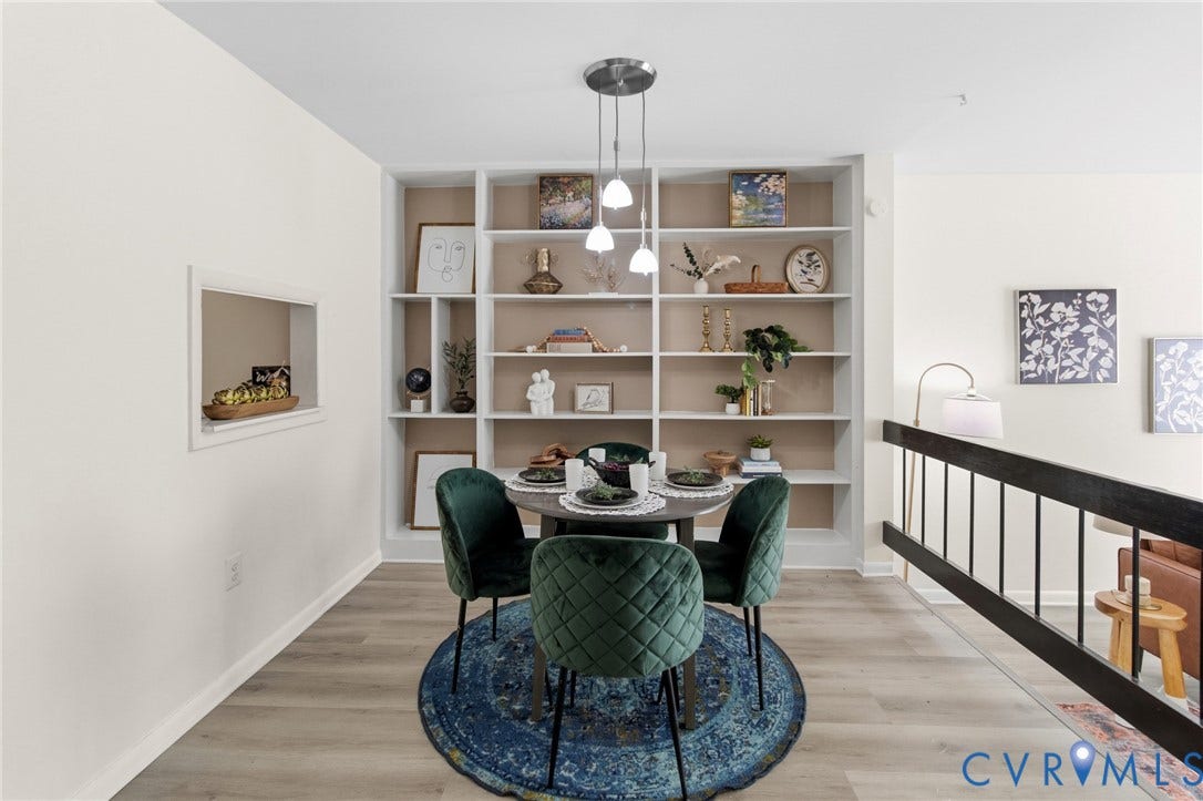 Recessed built-in shelving, wood-finish flooring, and a contemporary multi-pendant light fixture define this space