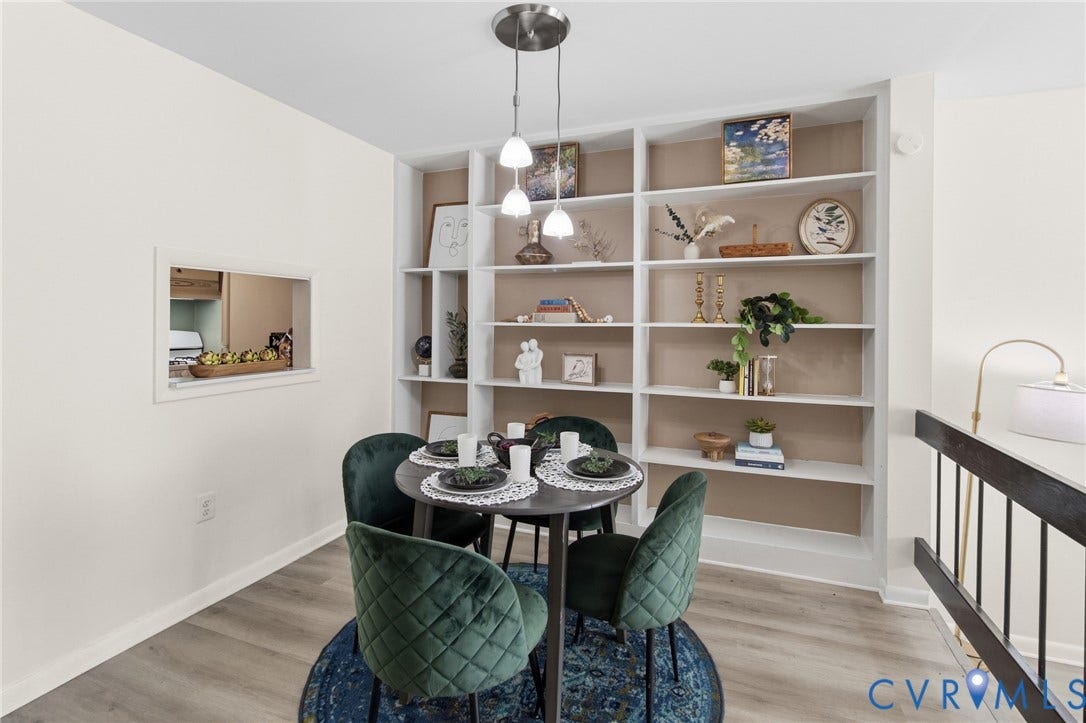 Built-in shelving, wood-finish flooring, recessed wall opening, pendant lighting fixture, and white painted walls