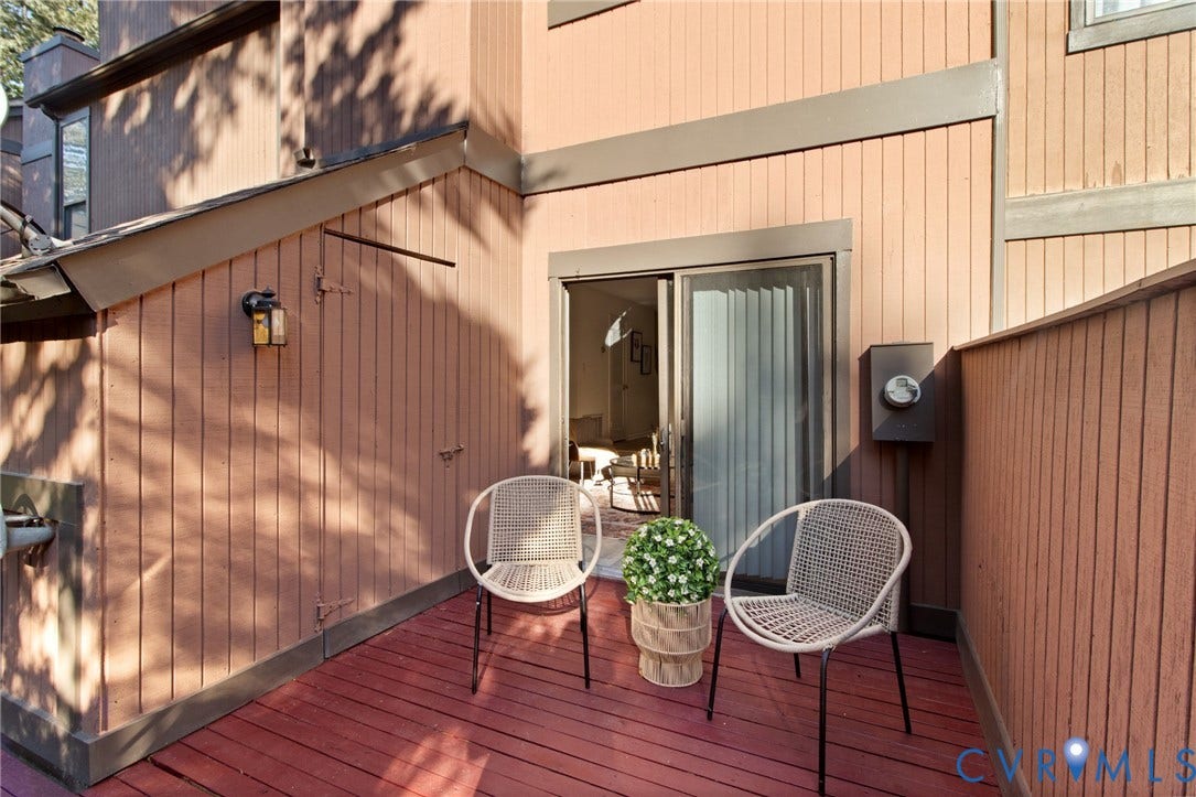 Private deck area with vertical wood siding and a sliding glass door
