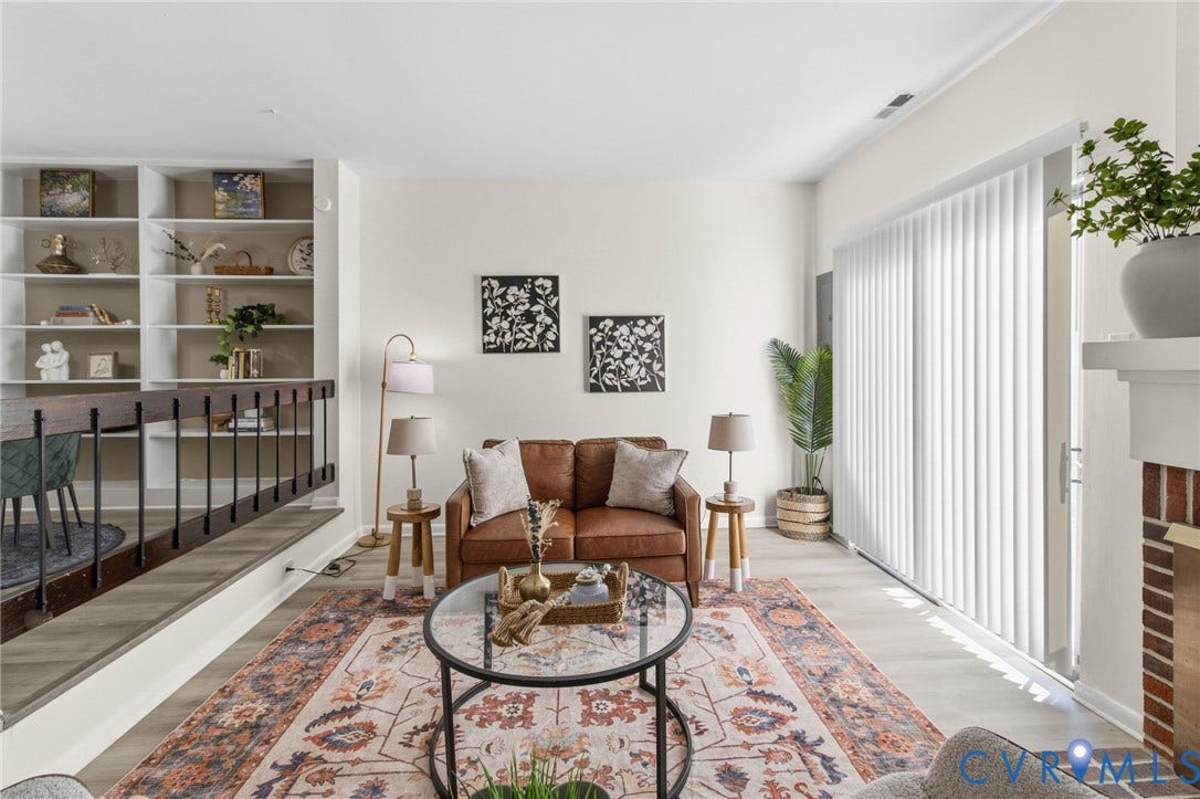 Built-in shelving, wood-finish flooring, brick fireplace surround, and a sliding glass door