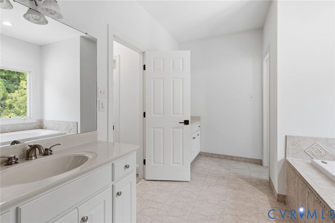 3808 Barrington Branch Court, Henrico, VA 23233 Dual vanities with integrated sinks and brushed nickel fixtures, tiled flooring, and a built-in soaking tub with decorative tile surround