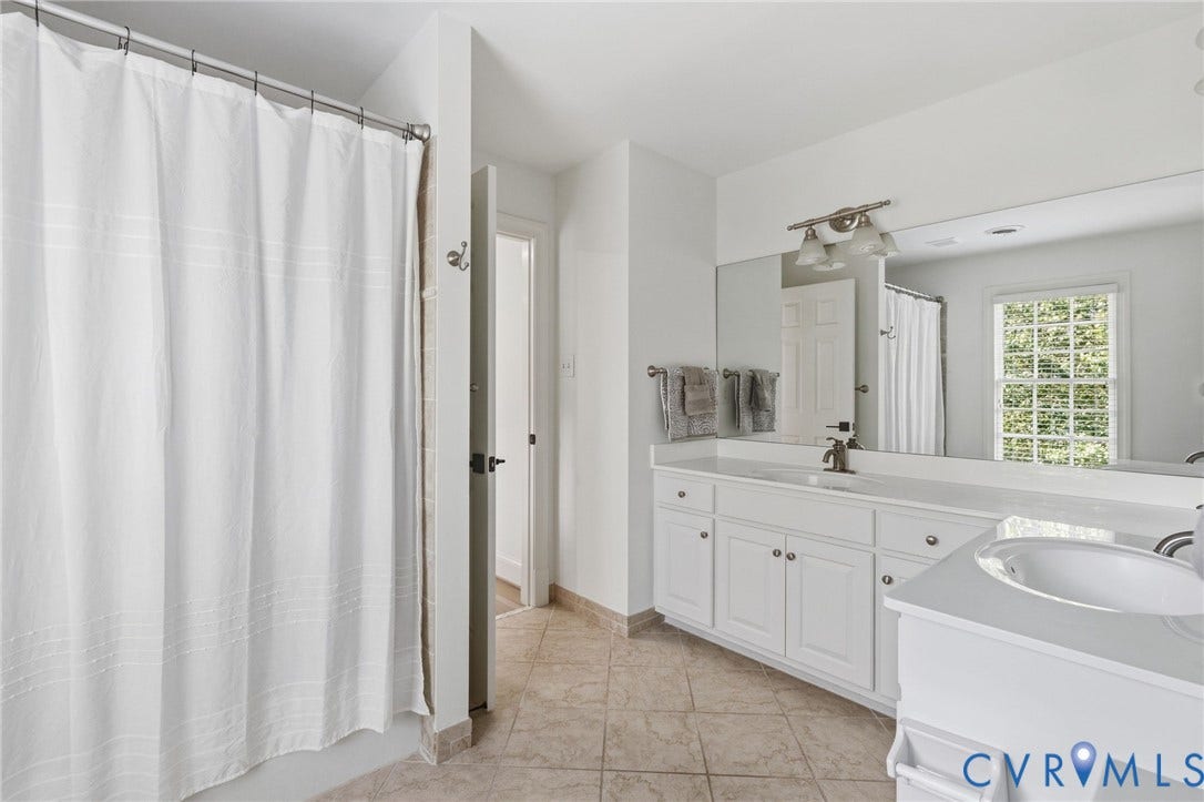 3808 Barrington Branch Court, Henrico, VA 23233 Dual vanity with white cabinetry and integrated sinks, large wall-mounted mirror, and tiled flooring