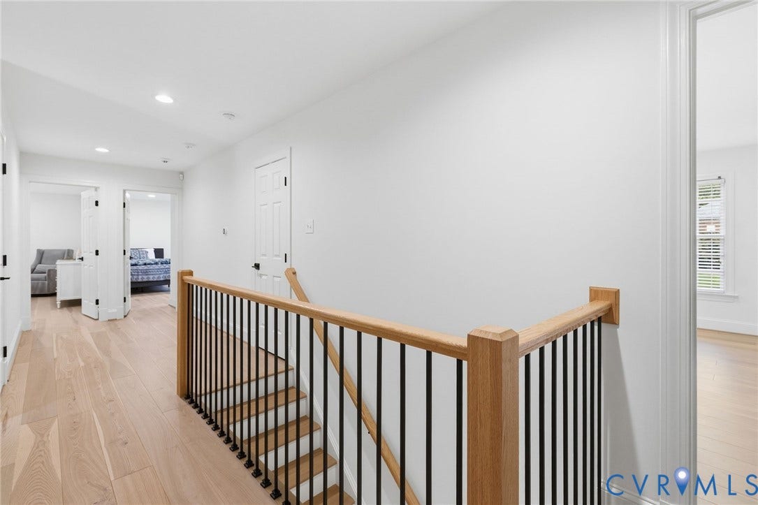 3808 Barrington Branch Court, Henrico, VA 23233 Hardwood flooring throughout, modern stair railing with wood handrail and black balusters, recessed lighting, and white paneled doors