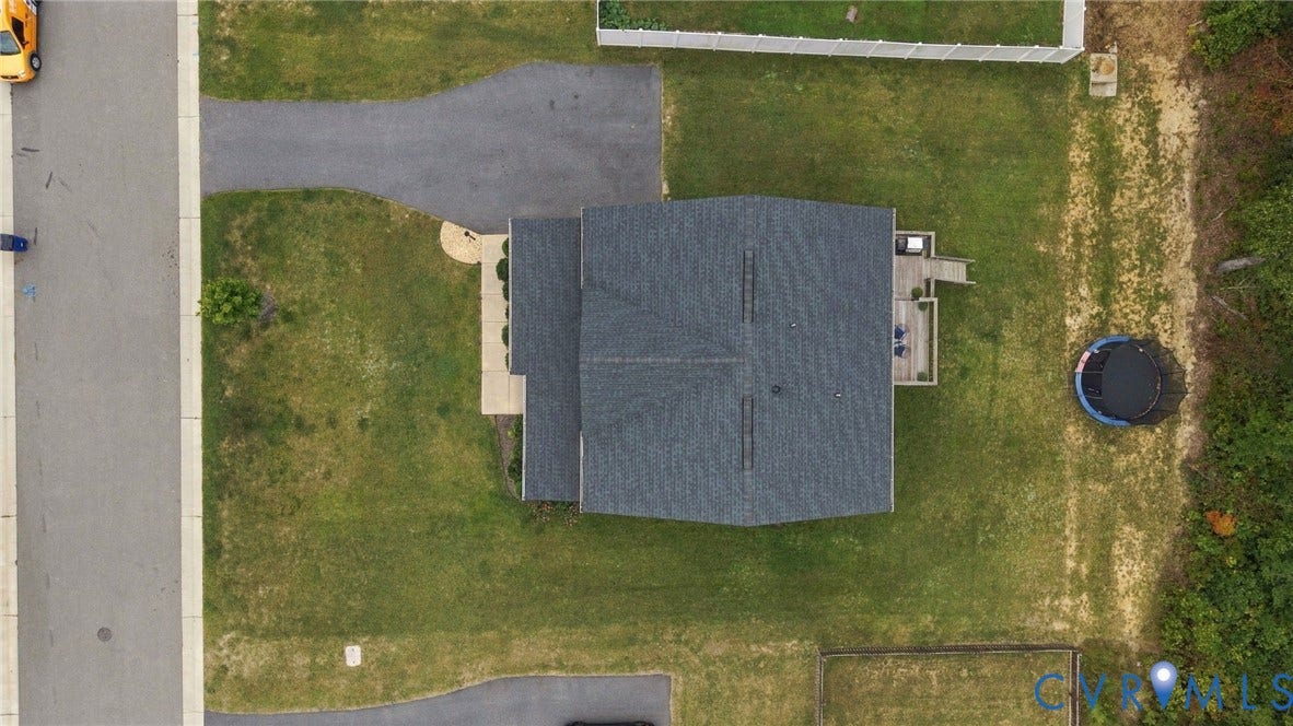 Paved driveway, dark shingle roof, wood-finish deck