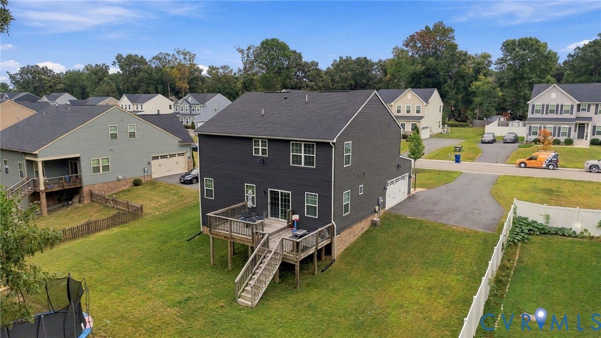 Two-story residence featuring dark gray siding, a dark shingle roof, and multiple windows