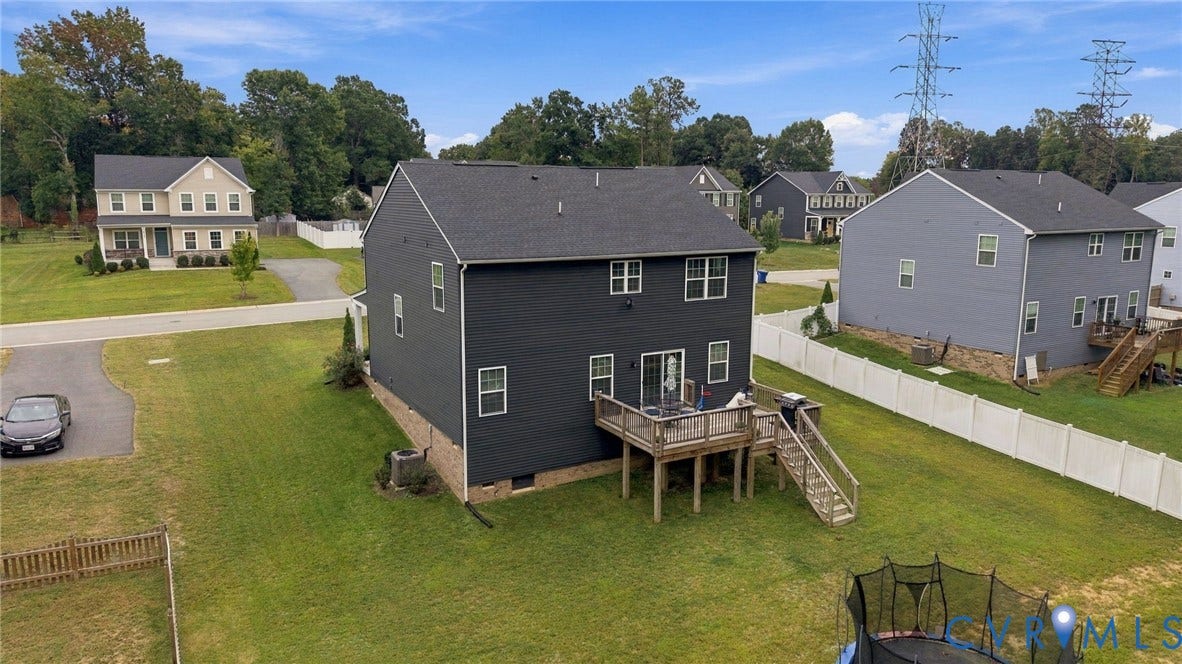 Dark gray siding exterior with a multi-level wood deck and stairs