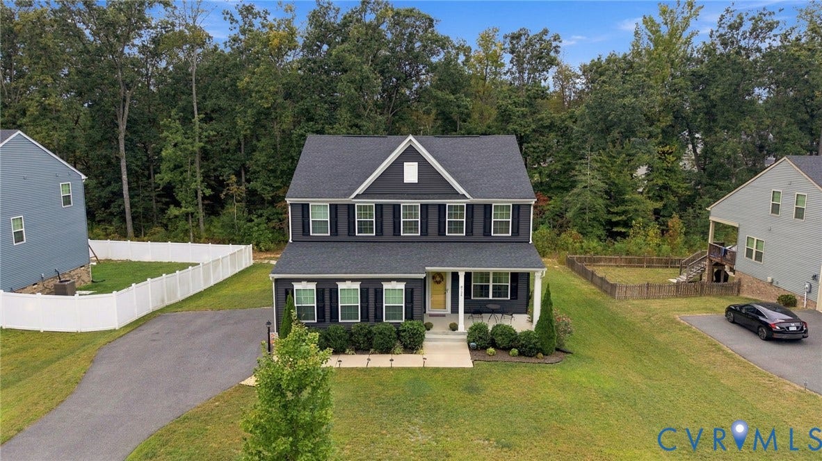 Two-story residence with dark siding, white trim, and a gabled roofline