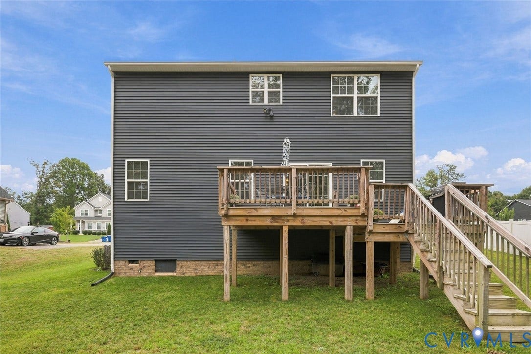 Expansive rear deck with wooden railings, providing a large outdoor living space