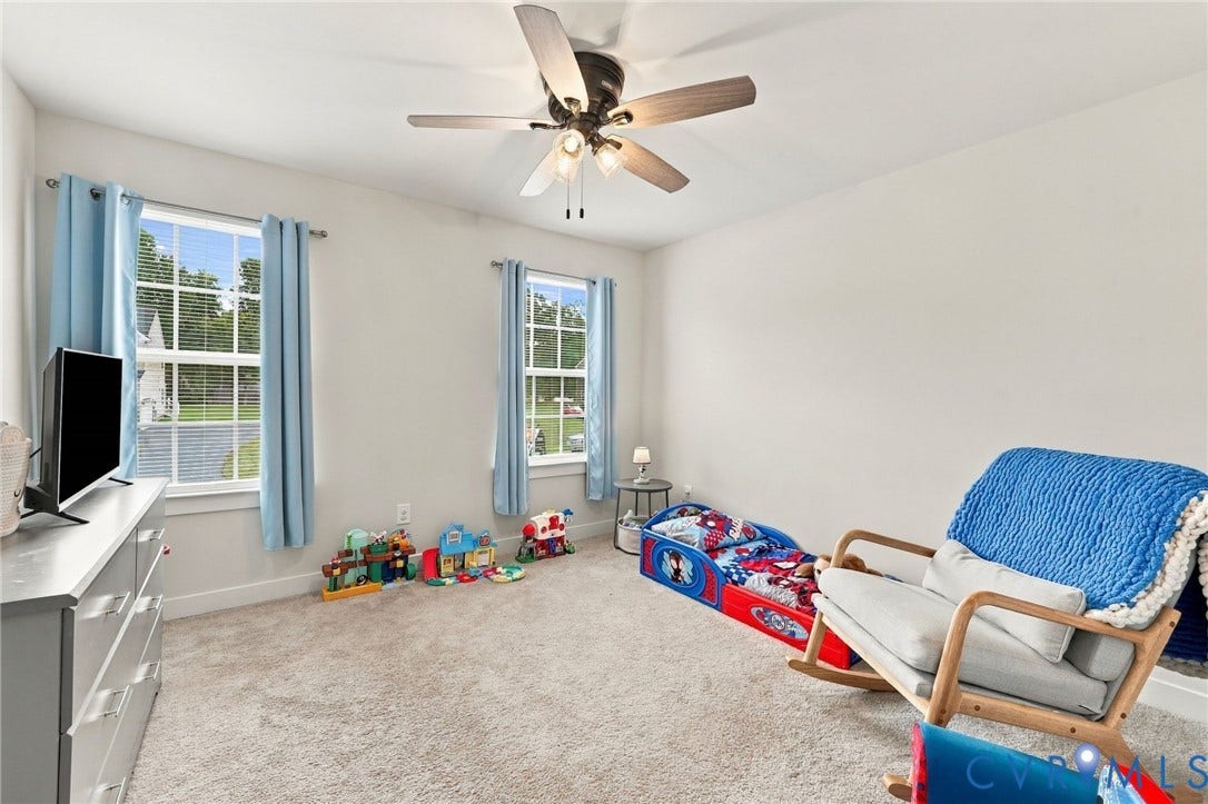 Carpeted flooring, two paneled windows, ceiling fan with integrated lighting, and neutral wall tones