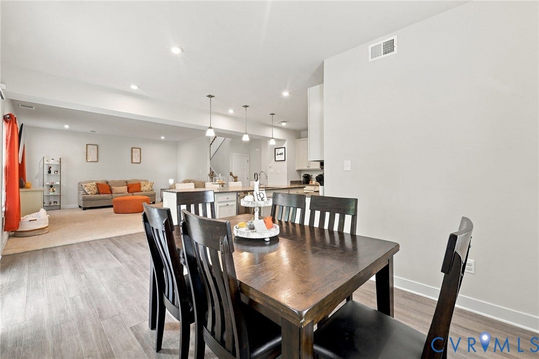 Open-concept living area with recessed lighting, wood-finish flooring, and a kitchen island with pendant lighting