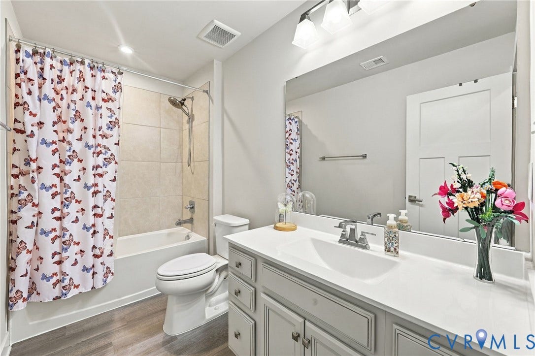 White vanity with shaker-style cabinetry, a white countertop, and a single basin sink