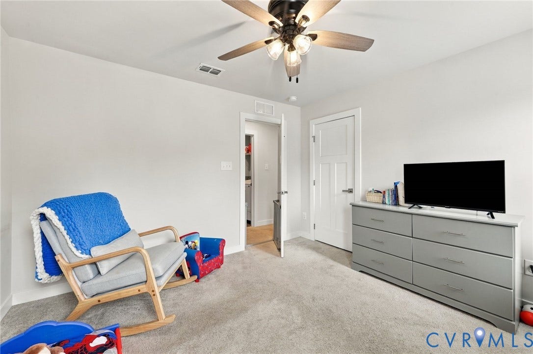 Light-colored carpeted flooring, neutral wall tones, and a ceiling fan with integrated lighting