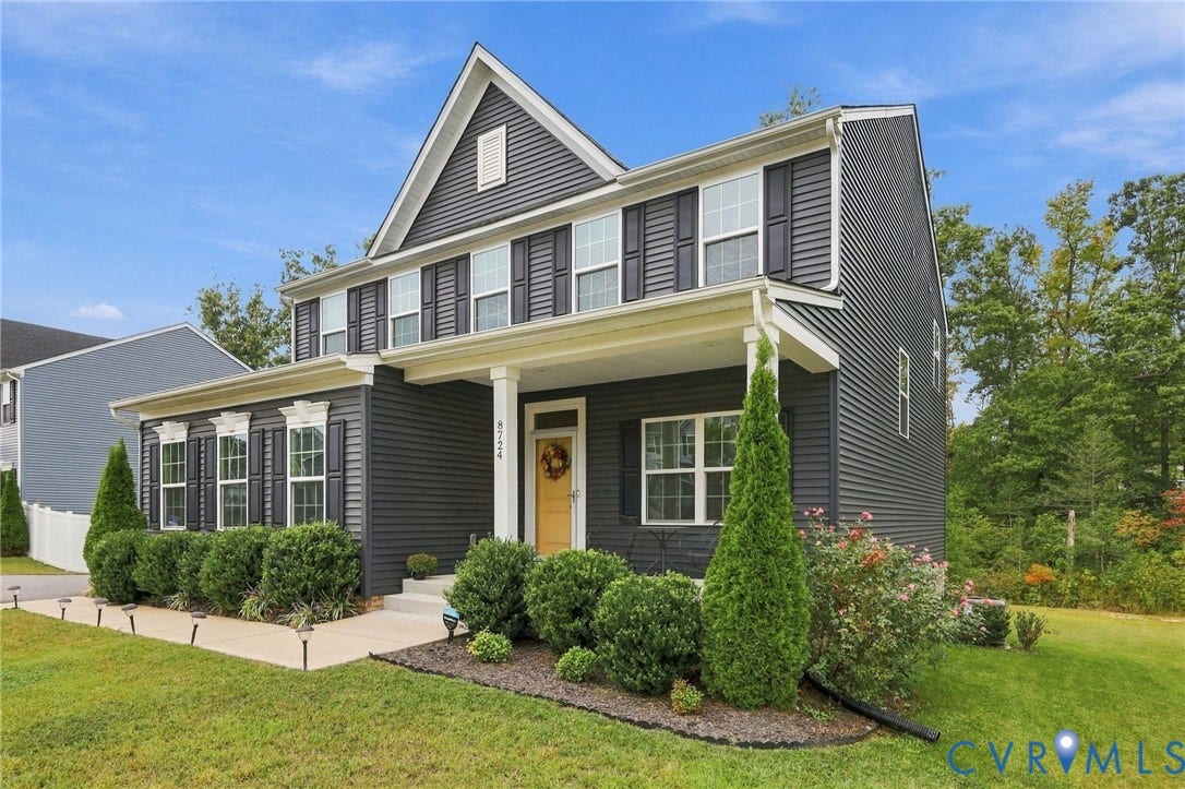 Two-story exterior with dark siding, white trim, and black shutters