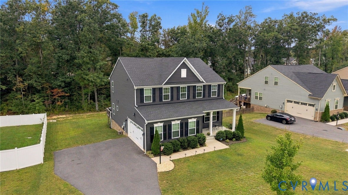 Two-story residence with a dark gray exterior, white trim, and a covered front porch