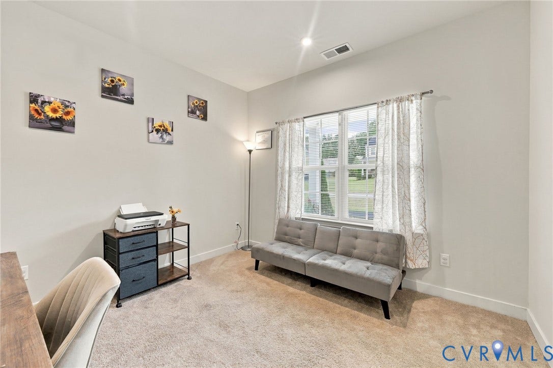 Carpeted flooring, white walls, and a window with blinds