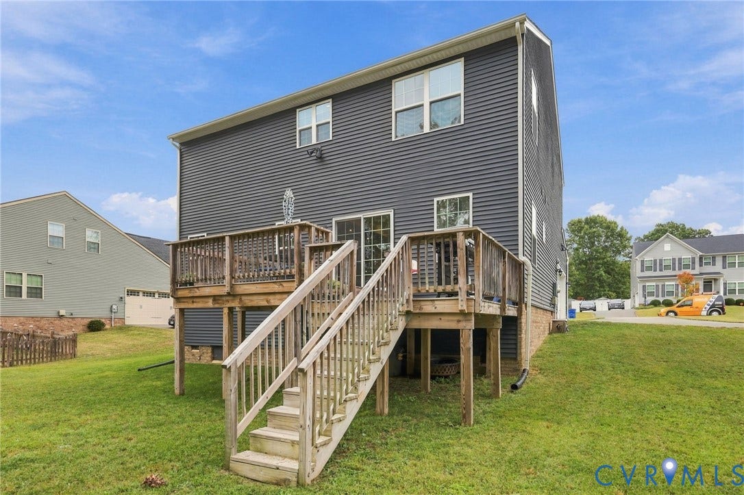 Multi-level wood deck with stairs leading to a grassy yard