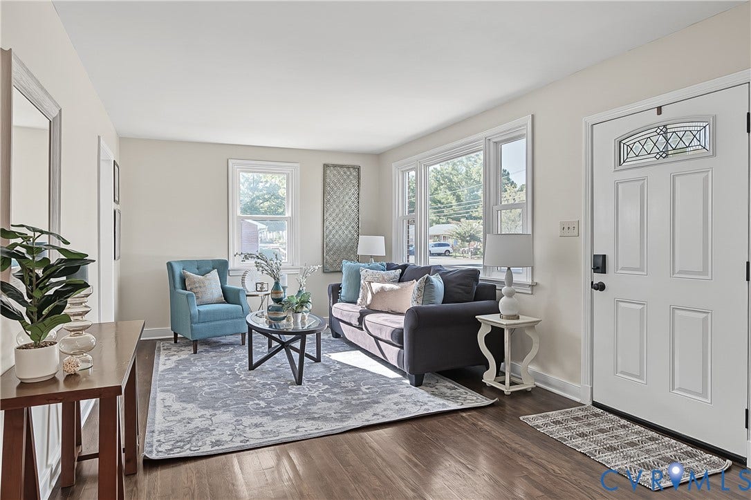 Open-feeling living space with natural light, fresh paint (2026), and warm wood flooring.