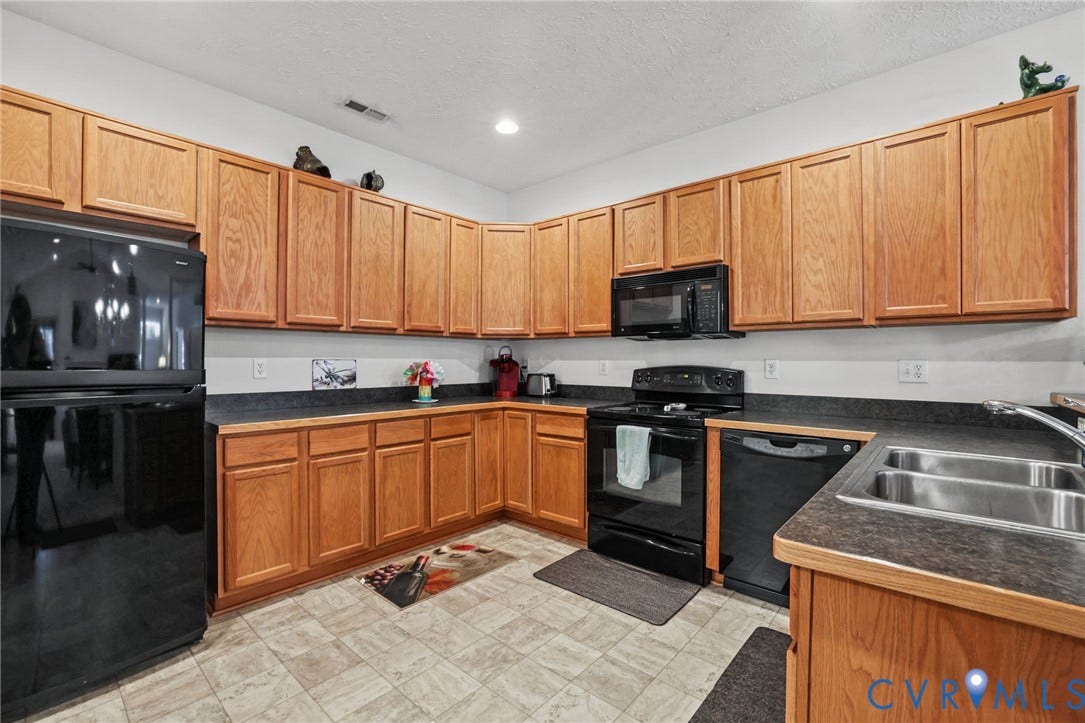 251 Pumpkin Place, Harvest Glen, North Chesterfield, VA 23236 Kitchen featuring extensive wood-finish cabinetry, black appliances, a double basin stainless steel sink, and durable tile flooring