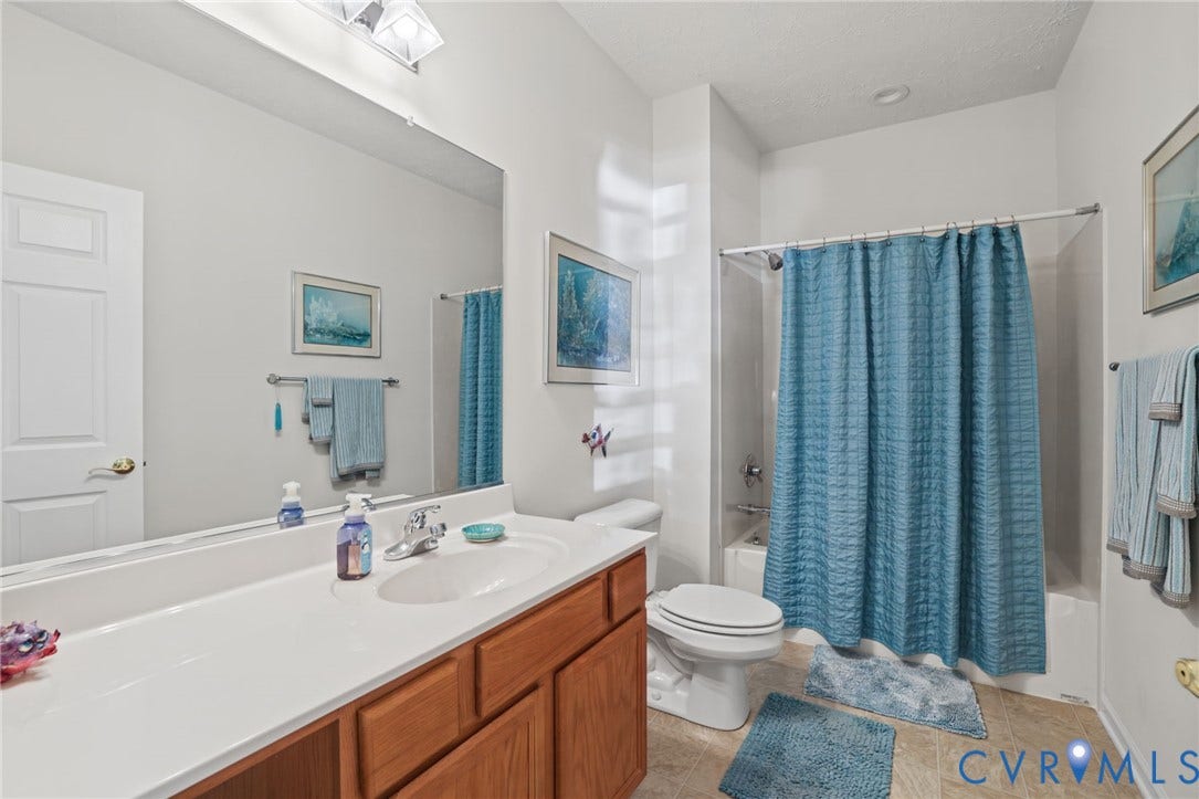 251 Pumpkin Place, Harvest Glen, North Chesterfield, VA 23236 Bathroom featuring a white vanity countertop, wood-finish cabinetry, and a full-size tub with shower