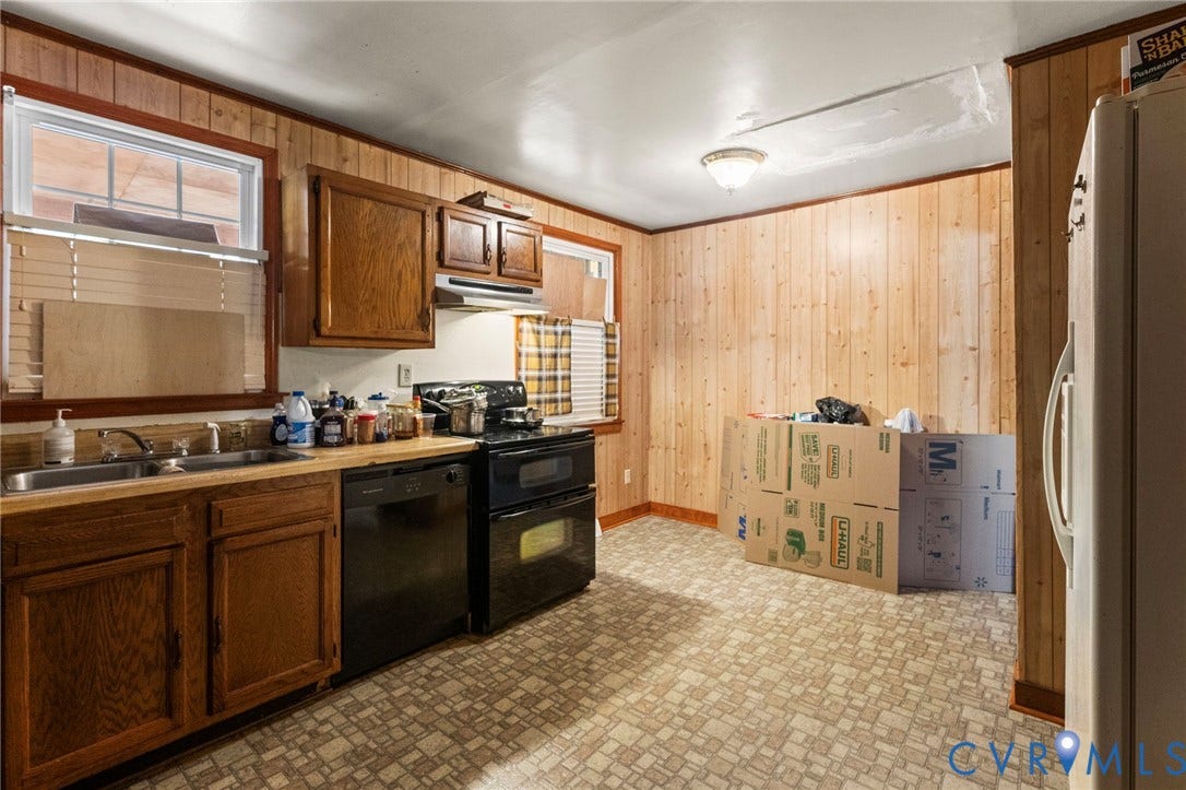 3917 Peyton Avenue, Richmond, VA 23224 Wood-paneled walls with a light fixture, featuring a double-basin sink, black dishwasher, and black double oven