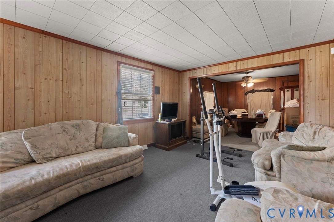 3917 Peyton Avenue, Richmond, VA 23224 Wood paneling walls, neutral carpet flooring, dropped ceiling, and a cased opening to an additional room