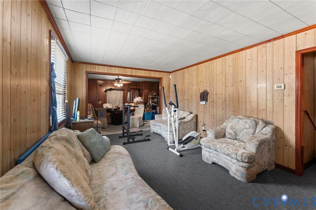 3917 Peyton Avenue, Richmond, VA 23224 Wood-paneled walls with dark wood trim, textured ceiling, and carpeting