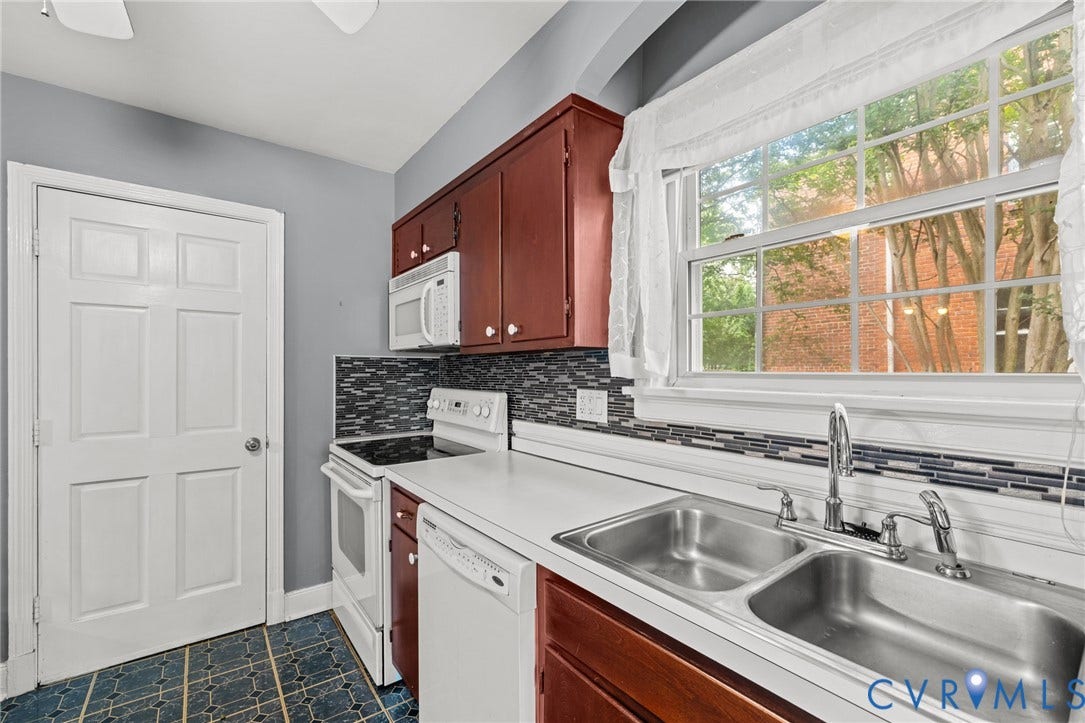 2405 Dumbarton Road, Henrico, VA 23228 Kitchen featuring wood cabinetry, white appliances, a double basin stainless steel sink, a tile backsplash, and a large window