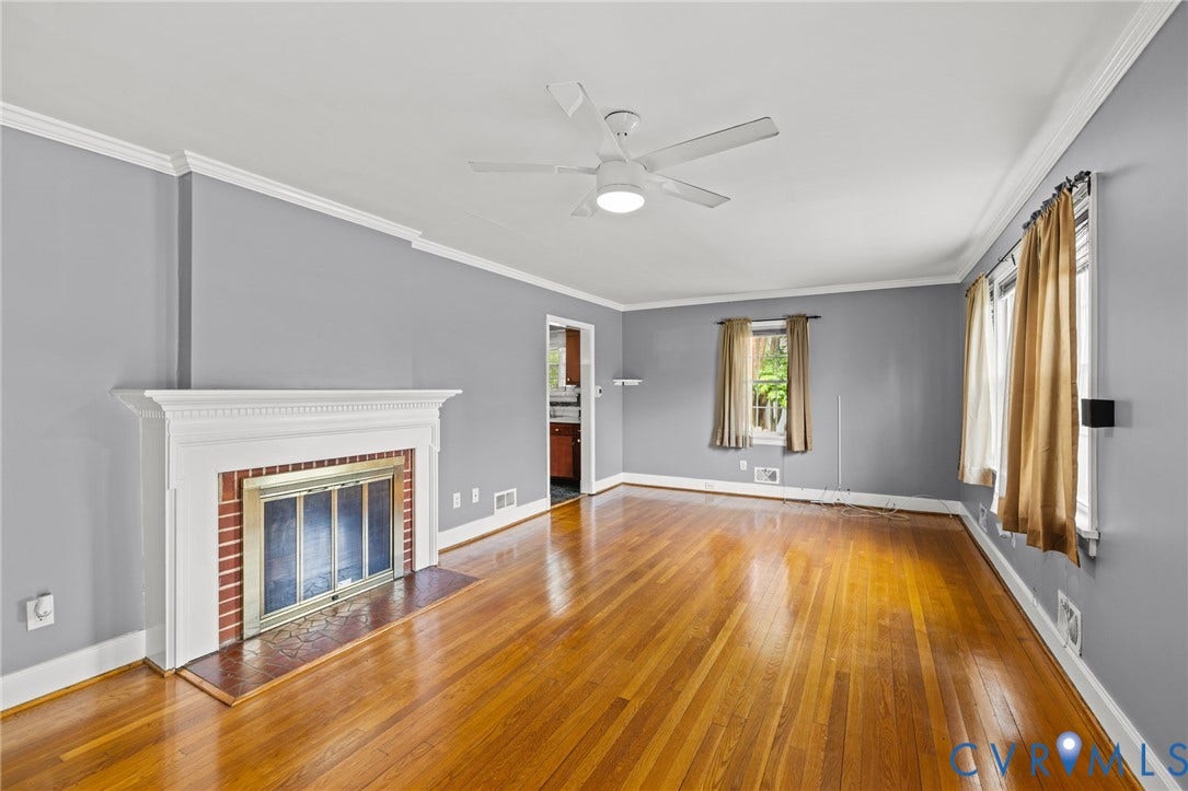 2405 Dumbarton Road, Henrico, VA 23228 Hardwood flooring, crown molding, a white mantel fireplace with a brass firebox, and a ceiling fan with integrated lighting