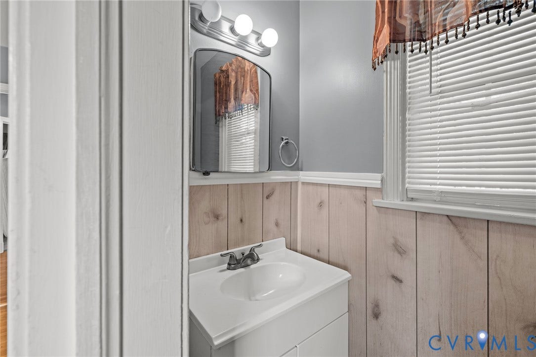 2405 Dumbarton Road, Henrico, VA 23228 Vanity with an integrated sink, polished chrome faucet, and a wall-mounted mirror