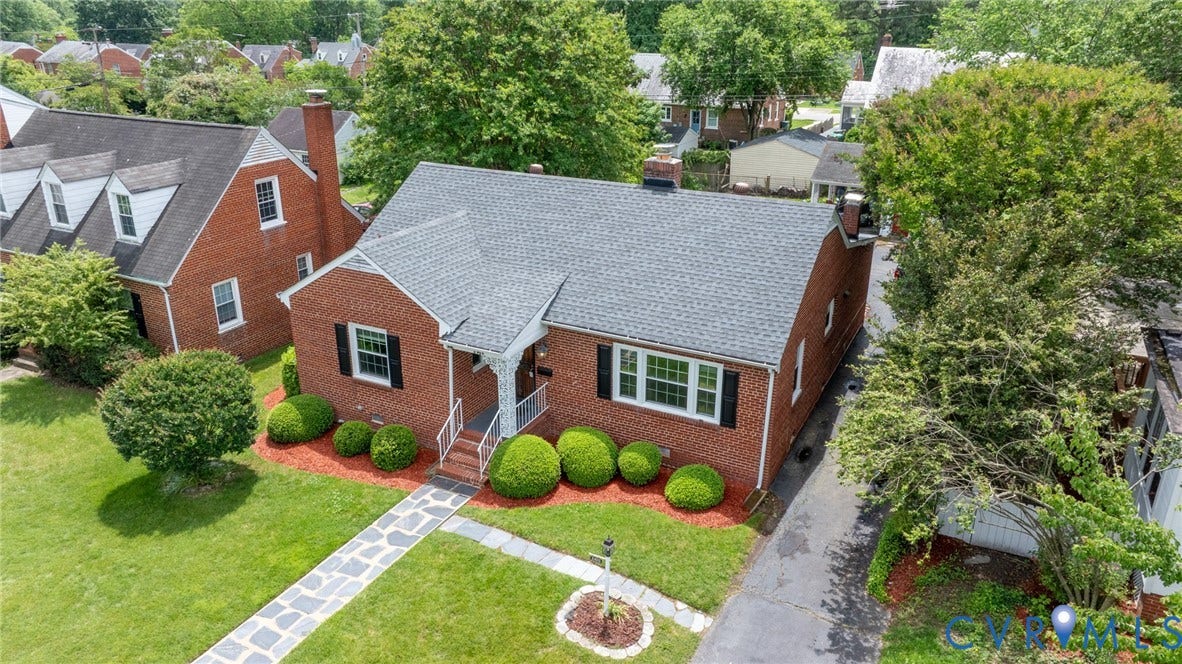 2405 Dumbarton Road, Henrico, VA 23228 Charming brick Colonial residence featuring a slate-gray asphalt shingle roof, symmetrical facade with multi-pane windows, and a welcoming front entry with brick steps