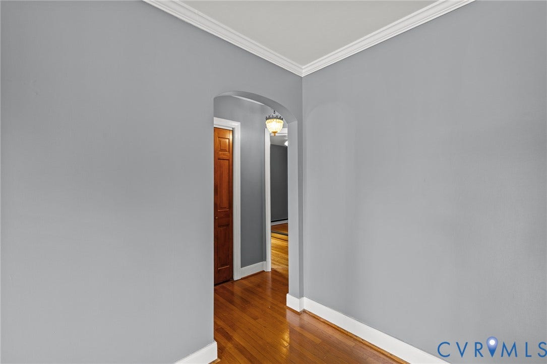 2405 Dumbarton Road, Henrico, VA 23228 Archway opening with wood-finish flooring, crown molding, and a built-in light fixture