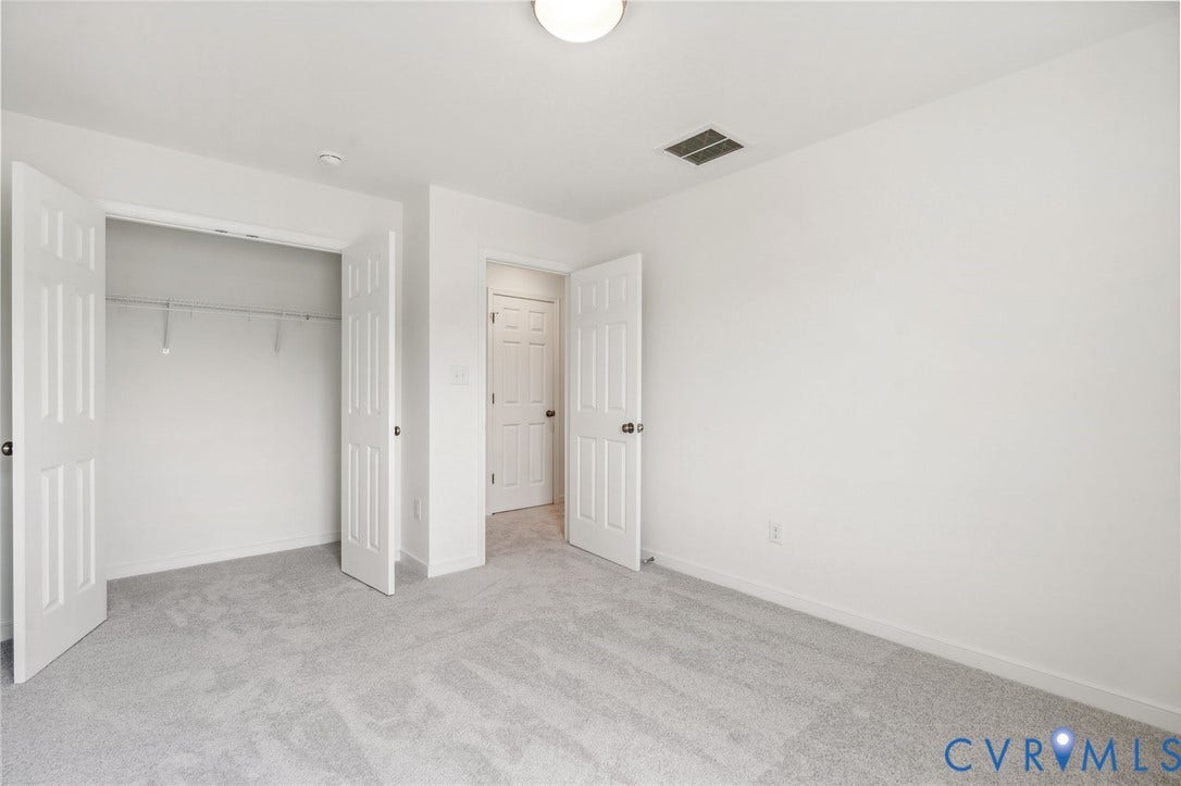9116 TERROIR Lane, Viniterra Villas, New Kent, VA 23124 Neutral-toned wall-to-wall carpeting, white walls, flush mount ceiling light, and a built-in closet with wire shelving