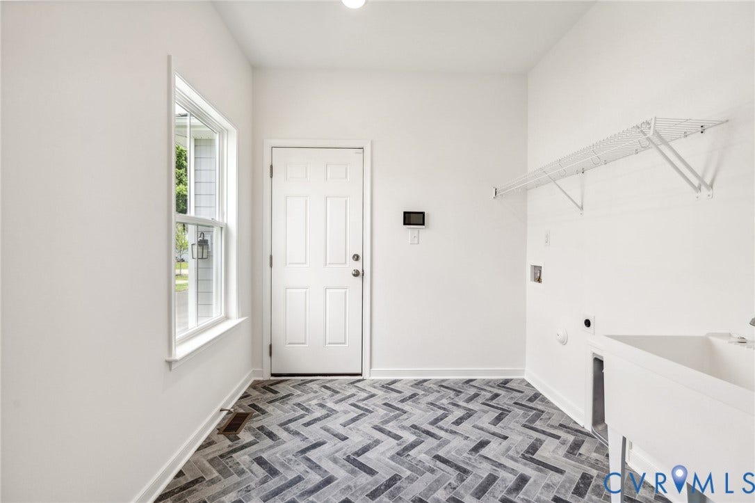 9116 TERROIR Lane, Viniterra Villas, New Kent, VA 23124 Herringbone-patterned floor tiles, white utility sink, white wire shelving, white paneled door, and a single-hung window