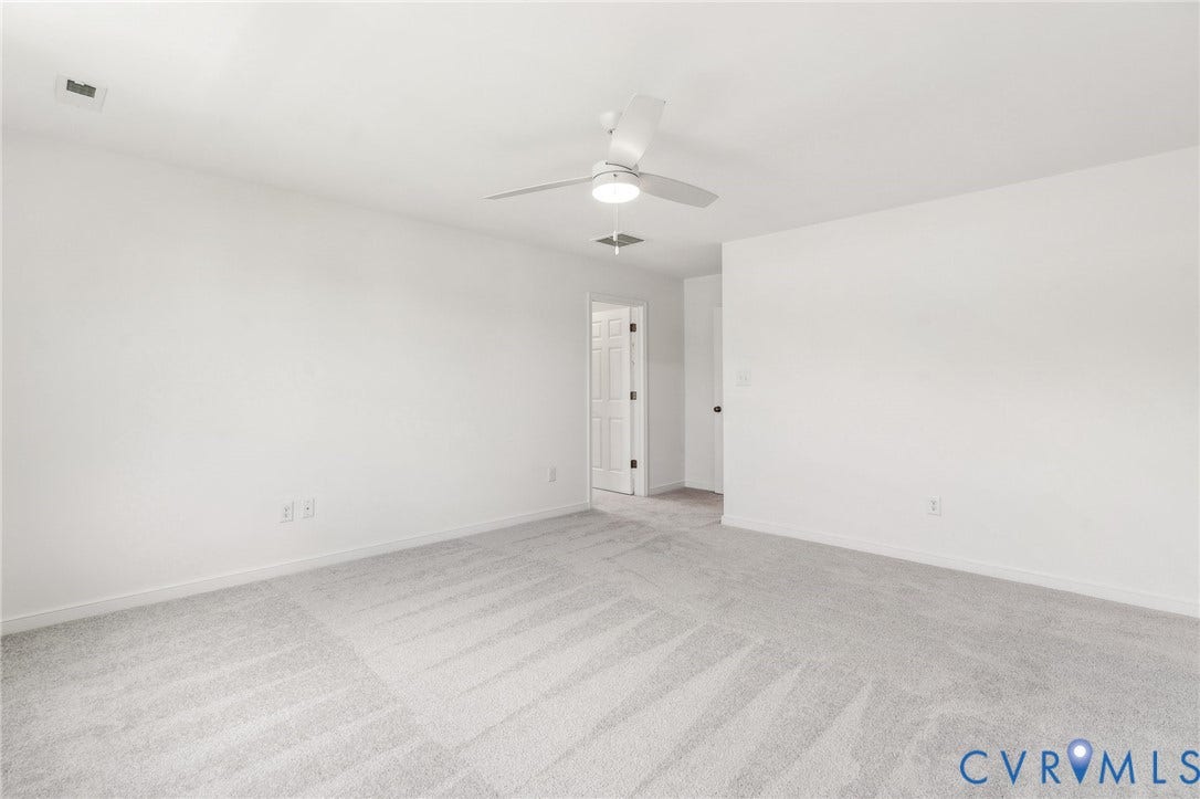 9116 TERROIR Lane, Viniterra Villas, New Kent, VA 23124 Expansive room featuring light gray carpeting, neutral wall color, and a ceiling fan with integrated lighting
