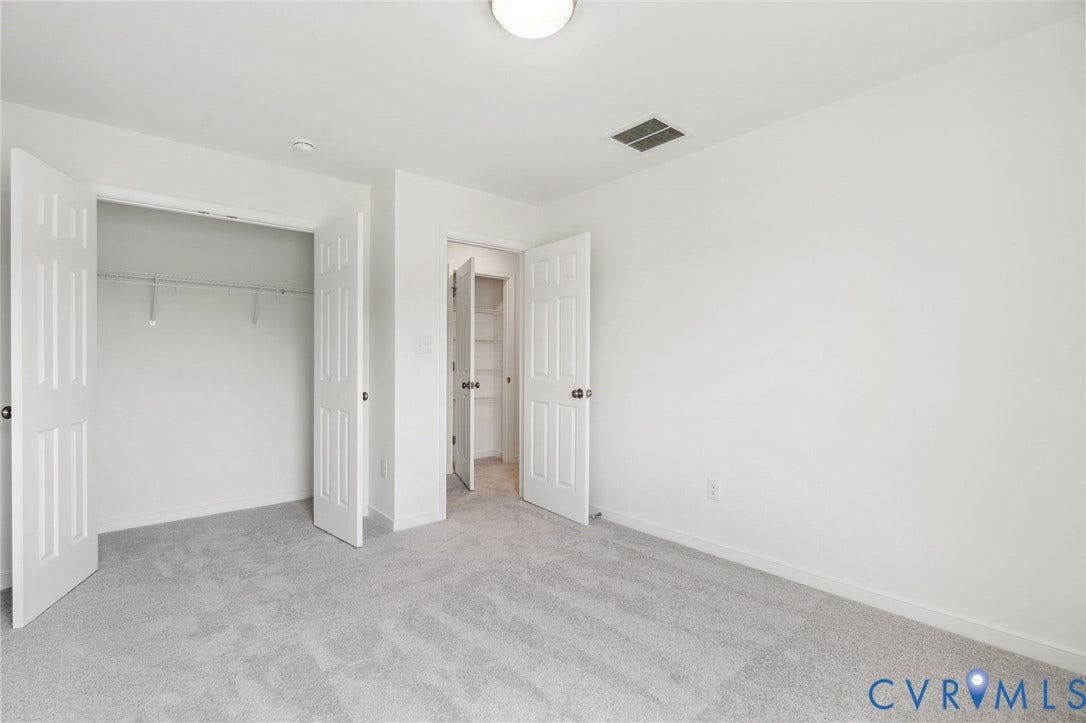 9116 TERROIR Lane, Viniterra Villas, New Kent, VA 23124 Light-hued wall-to-wall carpeting, white walls, overhead ceiling fixture, and a closet with bifold doors