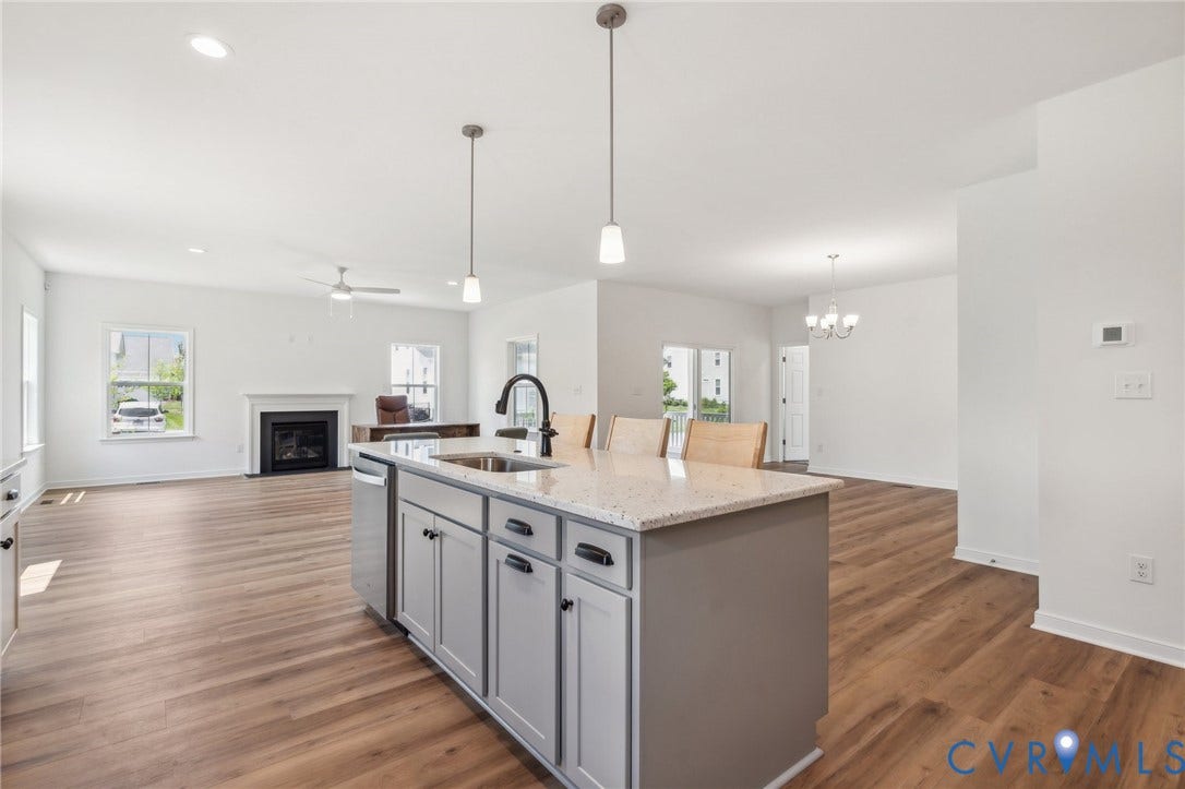 9116 TERROIR Lane, Viniterra Villas, New Kent, VA 23124 Kitchen island with integrated sink, stainless steel dishwasher, pendant lighting, and stone countertop