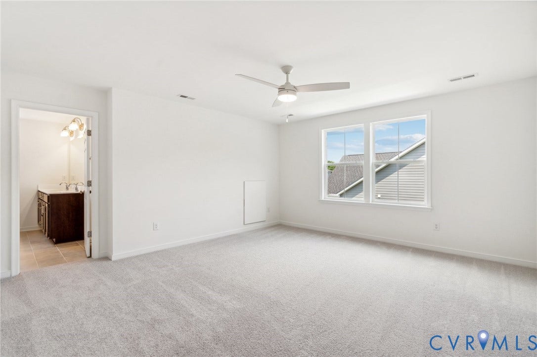 9116 TERROIR Lane, Viniterra Villas, New Kent, VA 23124 Spacious room featuring light gray carpeting, a ceiling fan with integrated lighting, and two large windows
