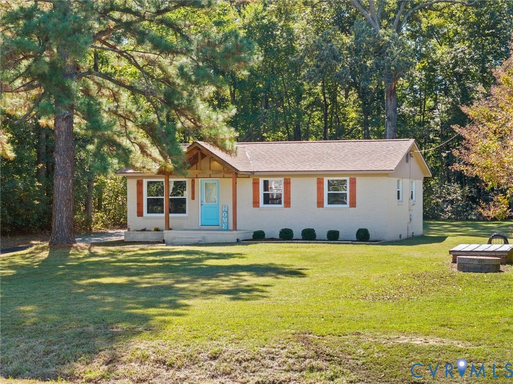 Single-story residence featuring a covered front porch, light-colored siding, and a gabled roof