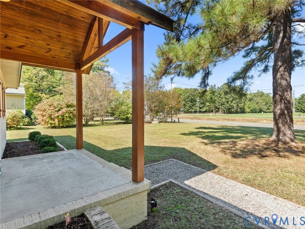 Front porch with a wood-plank ceiling, exposed wood beams, and concrete flooring
