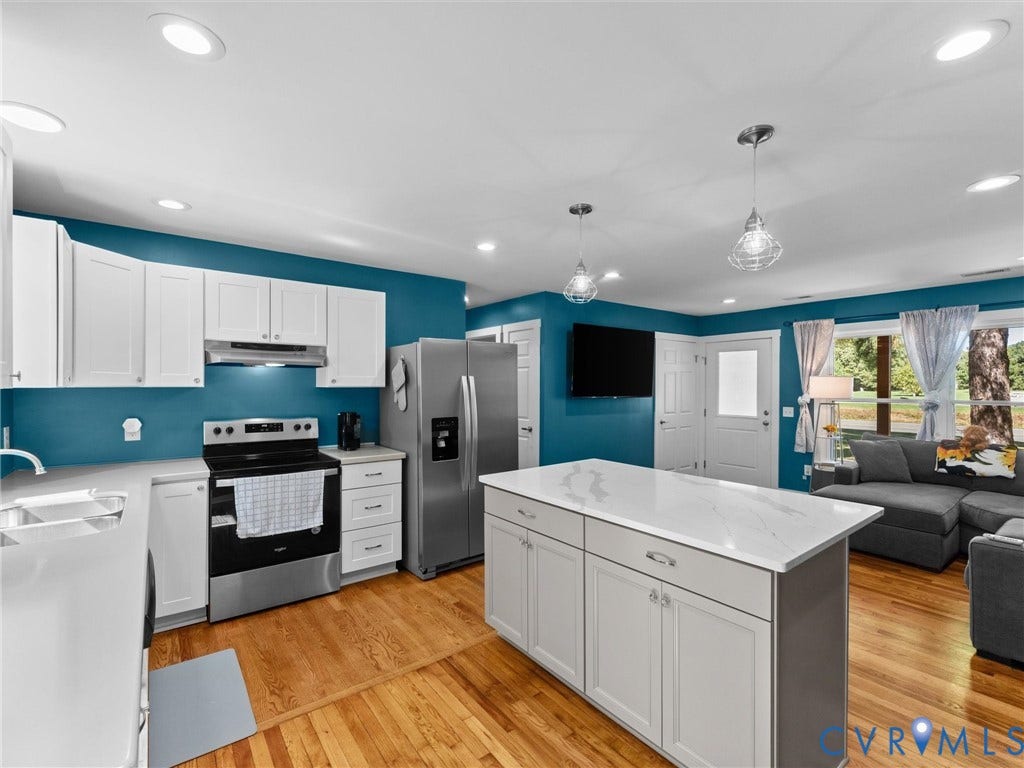 Kitchen featuring white cabinetry, stainless steel appliances, a center island with countertop, recessed lighting, and wood-finish flooring