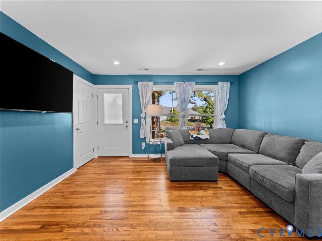 Hardwood-finish flooring, recessed lighting, and a white paneled door with frosted glass