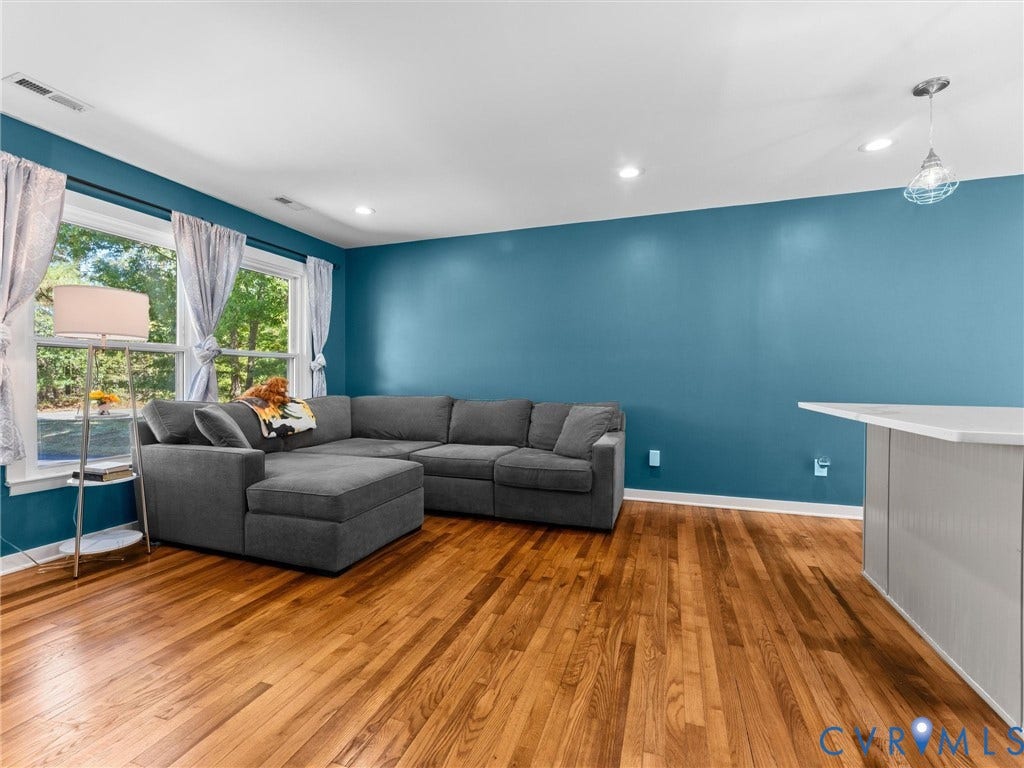 Hardwood flooring, recessed lighting, large windows, and a counter-height island