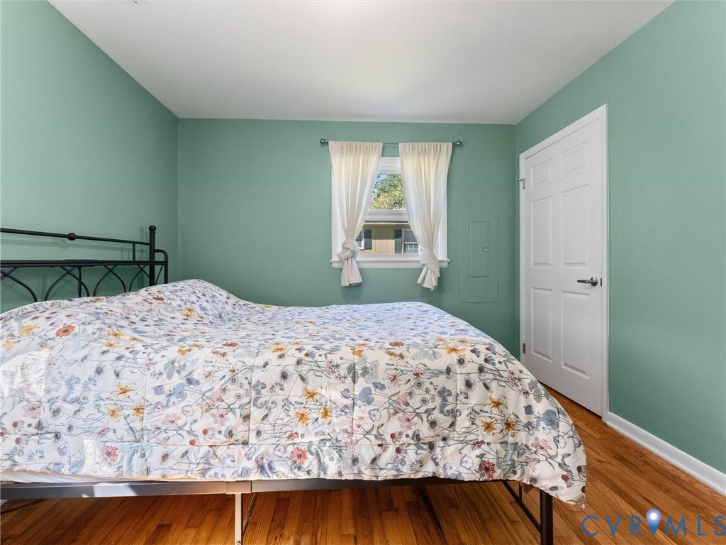 Hardwood flooring, painted walls, white trim, and a white paneled door