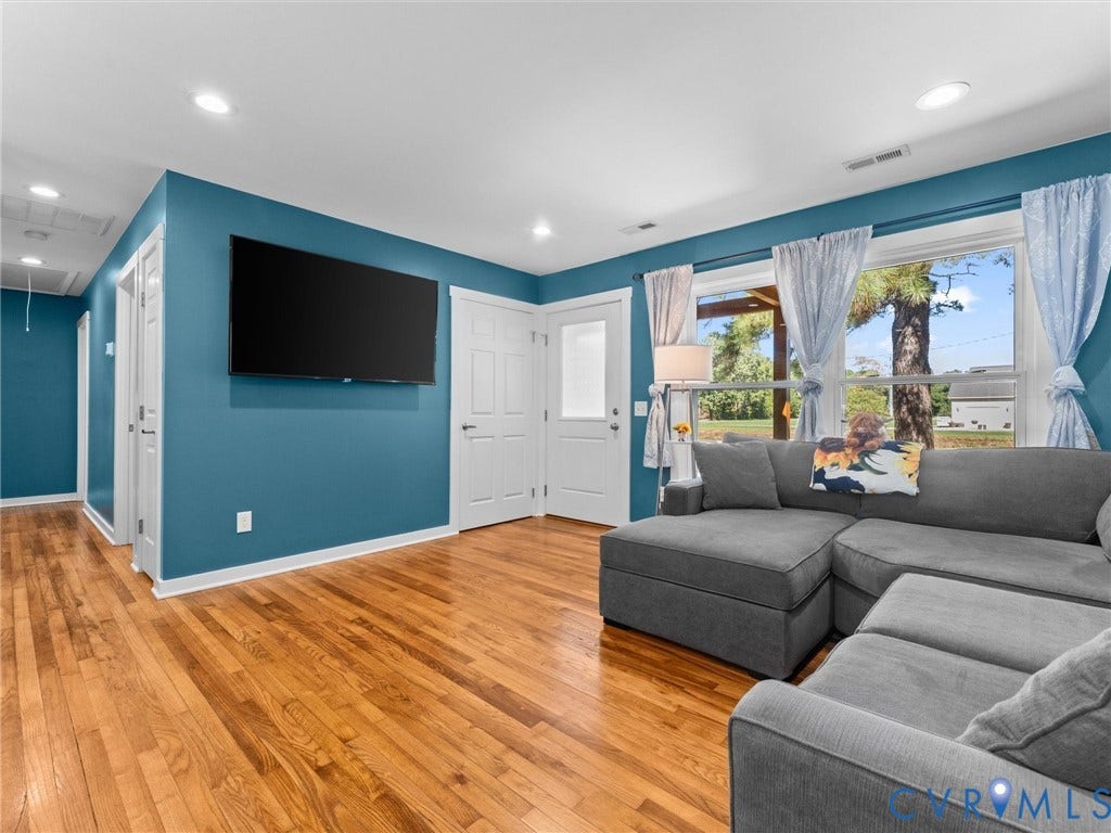 Hardwood flooring, recessed lighting, white trim, and a white paneled door with frosted glass